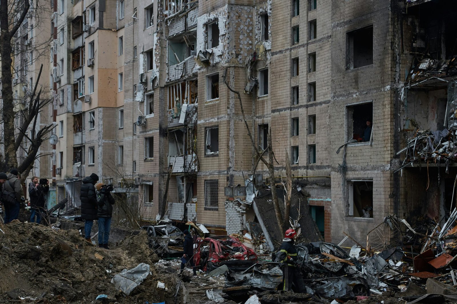 a group of people standing in front of a pile of rubble